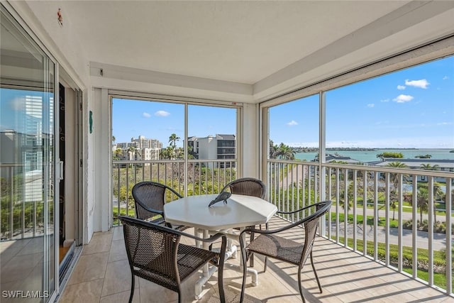 sunroom featuring a water view and a healthy amount of sunlight