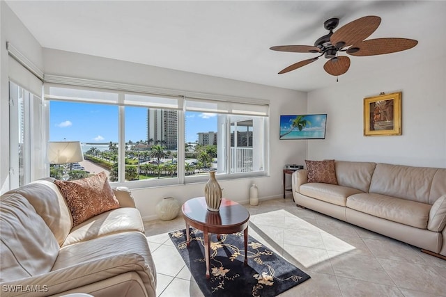 living area featuring baseboards, ceiling fan, and light tile patterned flooring