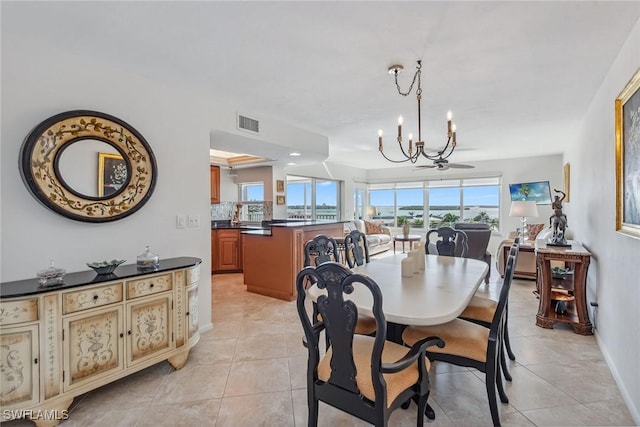 dining area with a notable chandelier, visible vents, baseboards, and light tile patterned flooring