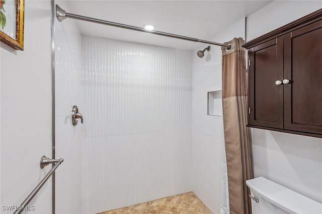 bathroom featuring toilet and tiled shower