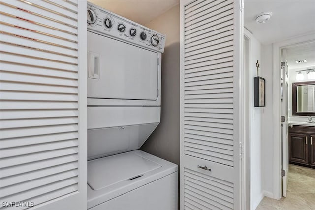 laundry area with a sink, laundry area, and stacked washer and dryer