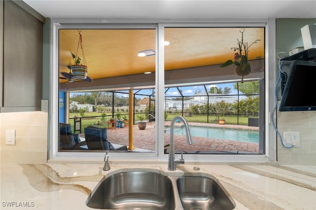 details with light stone counters, a sunroom, and a sink