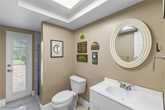 bathroom featuring baseboards, vanity, and toilet