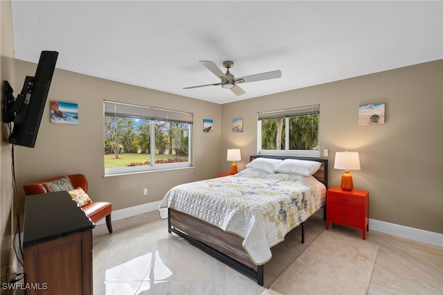 bedroom featuring ceiling fan, multiple windows, and baseboards