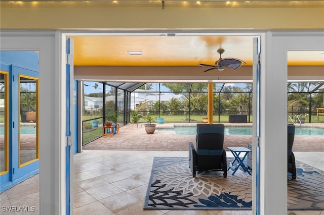 entryway with tile patterned flooring, a sunroom, and a ceiling fan