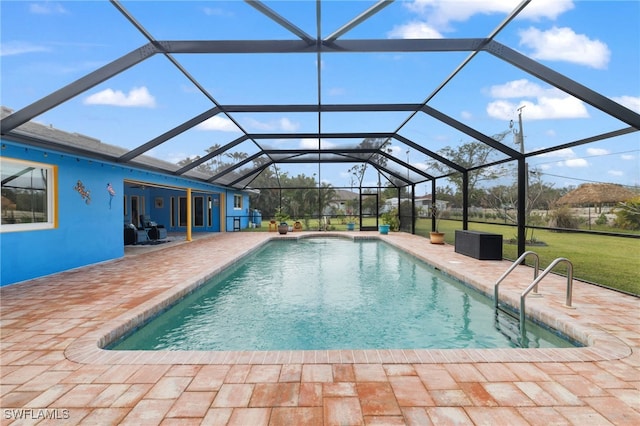 pool featuring glass enclosure, a lawn, and a patio