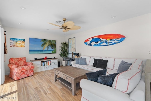 living room with light wood-style floors, visible vents, and a ceiling fan