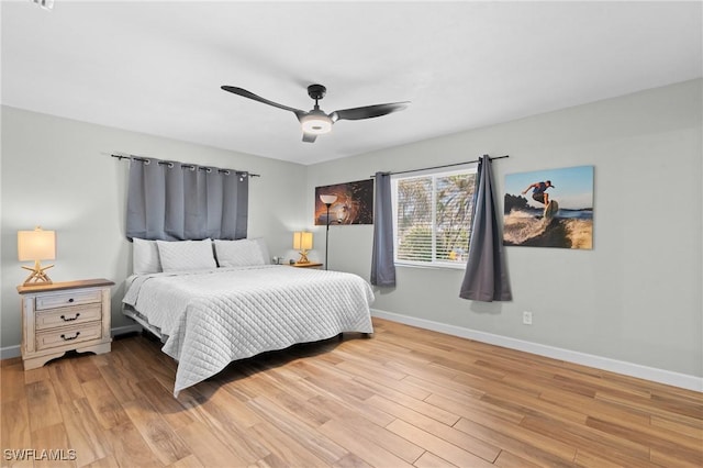 bedroom with light wood-style flooring, baseboards, and a ceiling fan