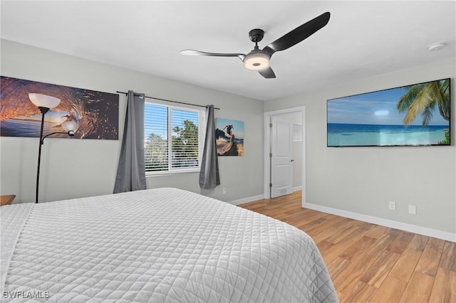 bedroom featuring a ceiling fan, baseboards, and wood finished floors