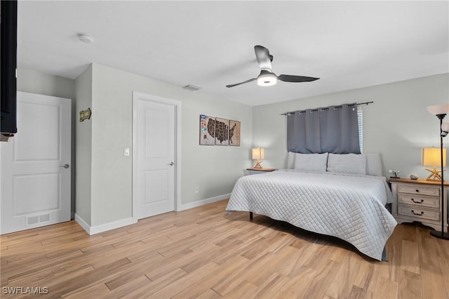 bedroom featuring light wood finished floors, visible vents, and baseboards