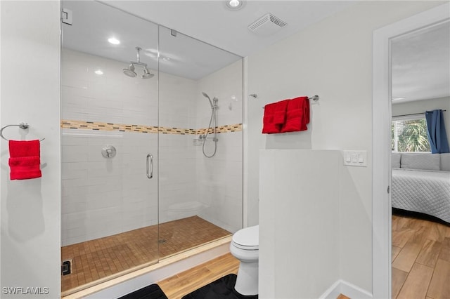 ensuite bathroom featuring visible vents, toilet, ensuite bath, and wood finished floors