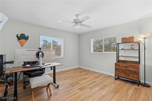 office area featuring a ceiling fan, light wood-type flooring, a wealth of natural light, and baseboards