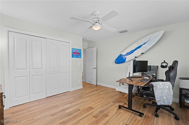 office area with light wood finished floors, visible vents, attic access, a ceiling fan, and baseboards