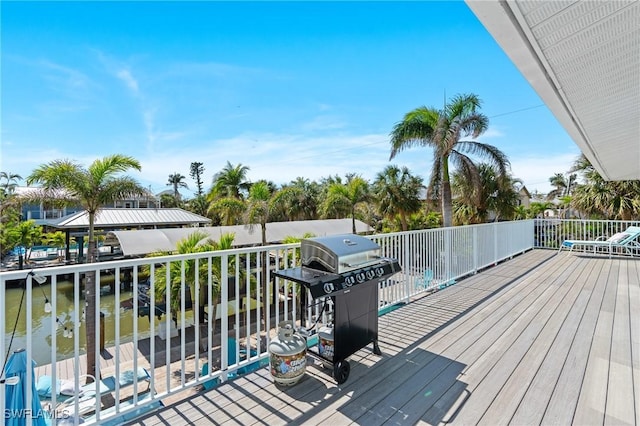 deck with a water view and area for grilling