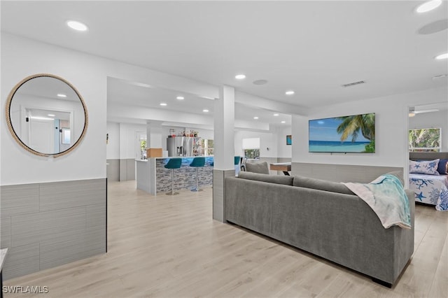 living area with recessed lighting, visible vents, and light wood finished floors