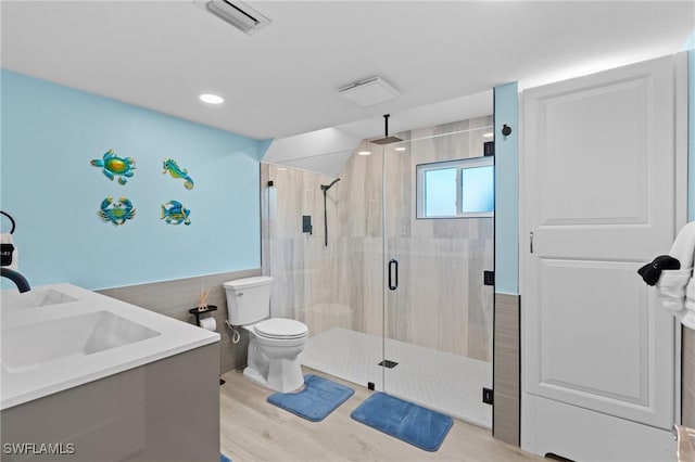 full bath featuring toilet, a sink, visible vents, a shower stall, and double vanity