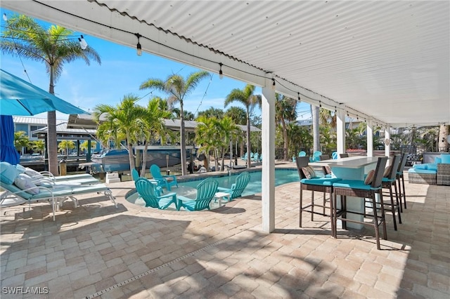 outdoor pool featuring exterior bar and a patio