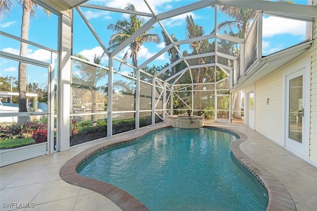 view of pool with glass enclosure, a pool with connected hot tub, and a patio area