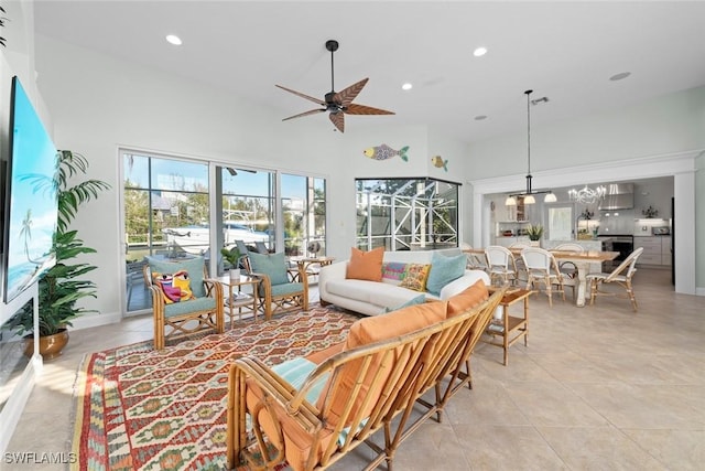 living room featuring light tile patterned floors, recessed lighting, a towering ceiling, and a ceiling fan