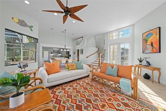 living room with a towering ceiling, ceiling fan, stairs, and recessed lighting