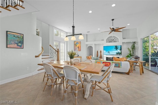 dining area featuring stairway, plenty of natural light, a towering ceiling, and recessed lighting