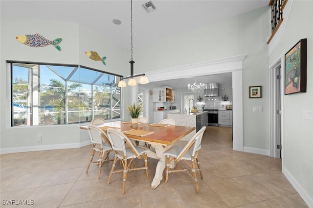 dining space with light tile patterned floors, baseboards, visible vents, a towering ceiling, and a sunroom