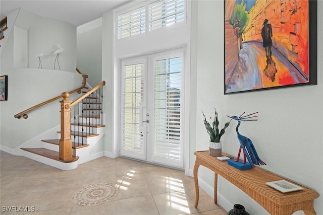 entrance foyer with french doors, stairway, baseboards, and light tile patterned floors