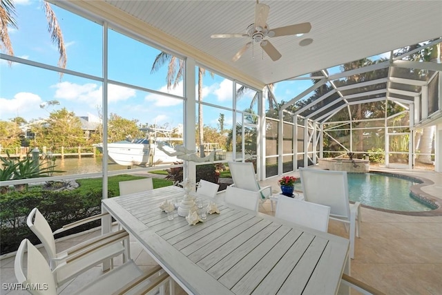 sunroom with ceiling fan, a water view, and a wealth of natural light