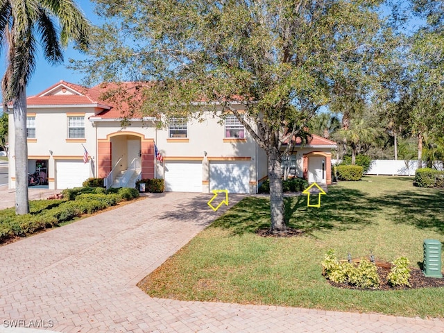 mediterranean / spanish house with a front lawn and a garage