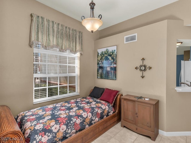 tiled bedroom featuring sink and white refrigerator