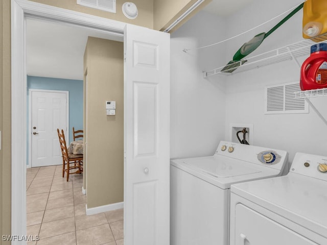 laundry area with washer and dryer and light tile patterned floors