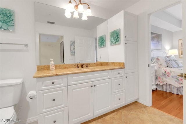 ensuite bathroom with a notable chandelier, visible vents, toilet, ensuite bathroom, and vanity