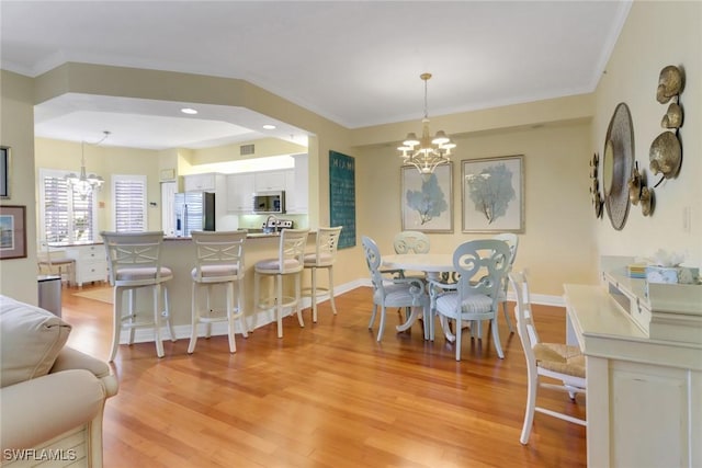 dining space featuring a notable chandelier, visible vents, light wood-style floors, baseboards, and crown molding