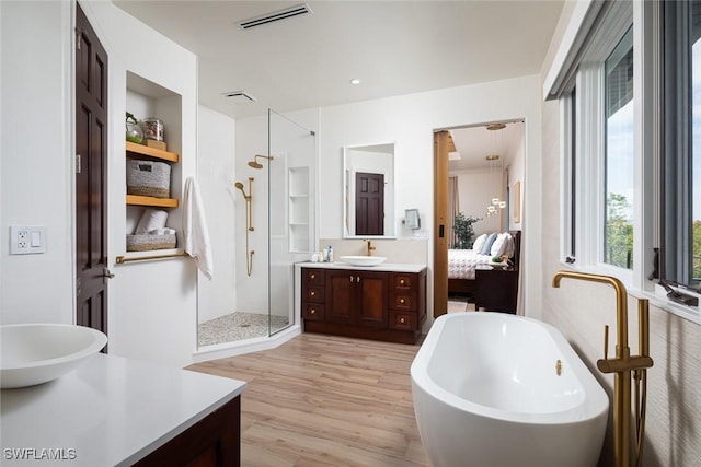 full bathroom featuring ensuite bathroom, wood finished floors, vanity, visible vents, and a stall shower