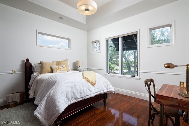 bedroom featuring baseboards and dark wood-style flooring