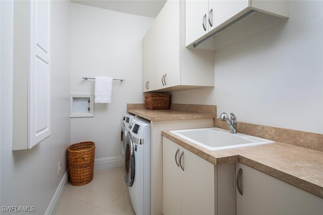 laundry room with light tile patterned floors, cabinet space, a sink, washer and dryer, and baseboards