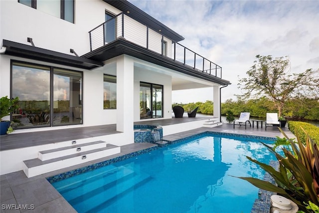 outdoor pool with a patio and an in ground hot tub