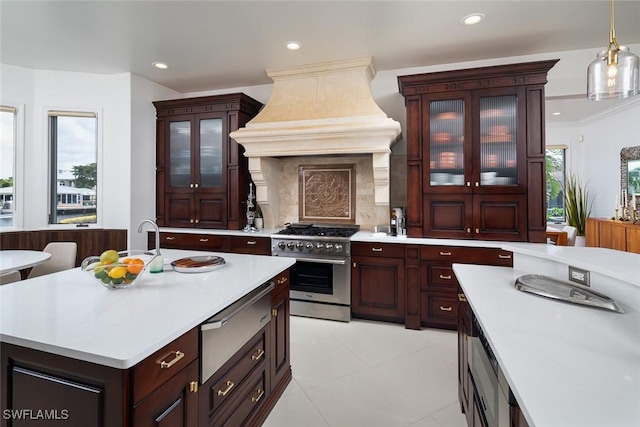 kitchen with light countertops, a healthy amount of sunlight, stainless steel stove, and custom range hood