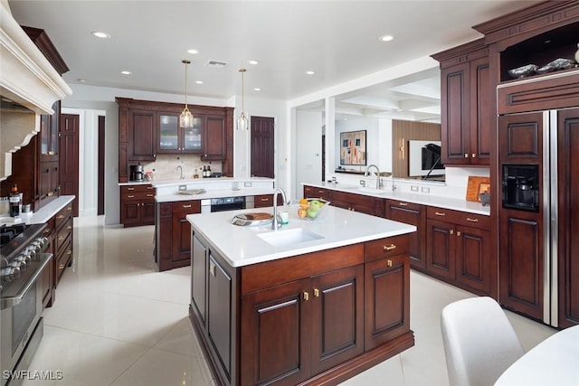 kitchen with premium appliances, a kitchen island with sink, a sink, and visible vents