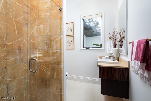 bathroom with a stall shower, baseboards, toilet, tile patterned flooring, and vanity