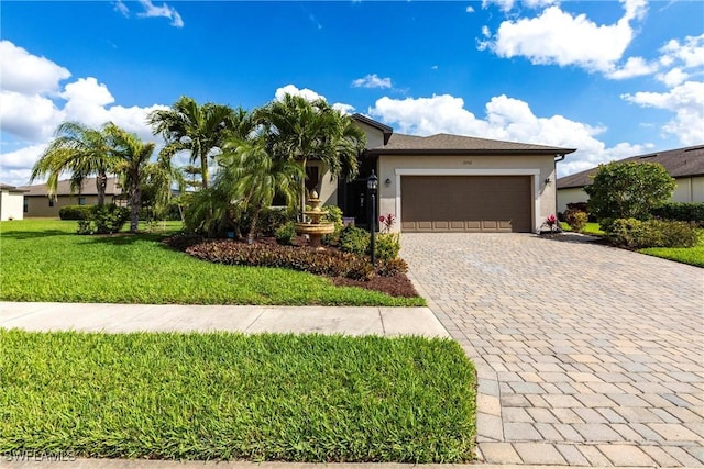 view of front of house featuring stucco siding, an attached garage, decorative driveway, and a front yard