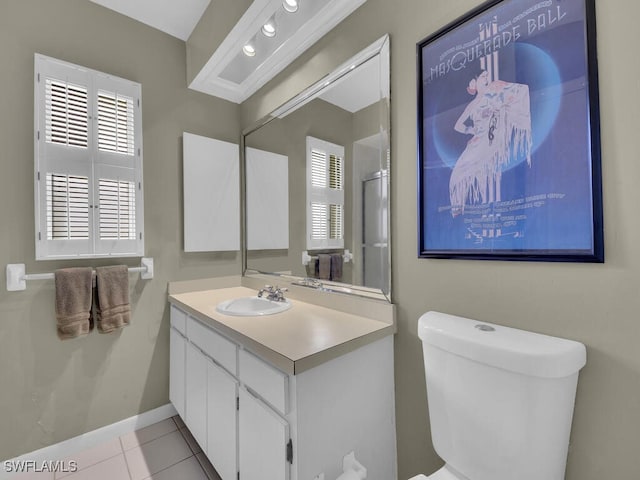 bathroom featuring toilet, plenty of natural light, tile patterned flooring, and vanity