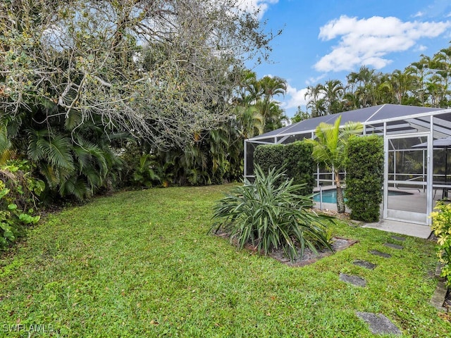 view of yard with glass enclosure and an outdoor pool