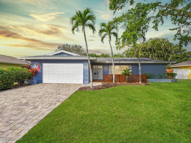 ranch-style house with a garage, decorative driveway, and a front yard