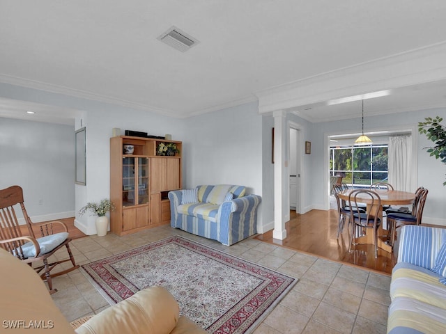 tiled living area with crown molding, visible vents, decorative columns, and baseboards