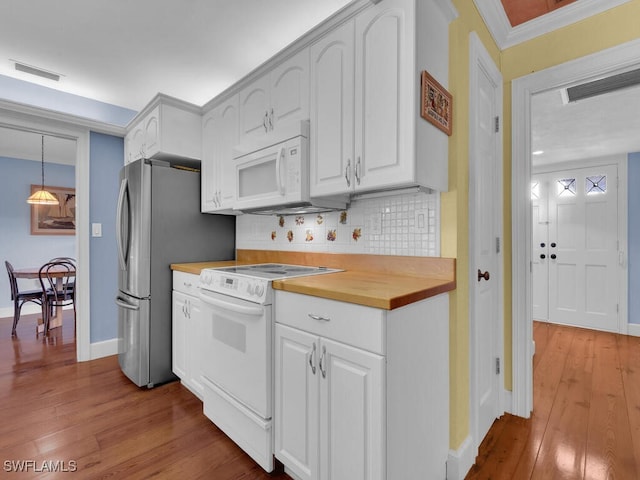 kitchen featuring white appliances, wood-type flooring, visible vents, and decorative backsplash