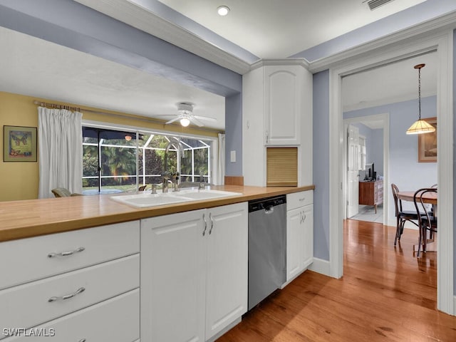 kitchen featuring wooden counters, stainless steel dishwasher, white cabinetry, a sink, and light wood-type flooring