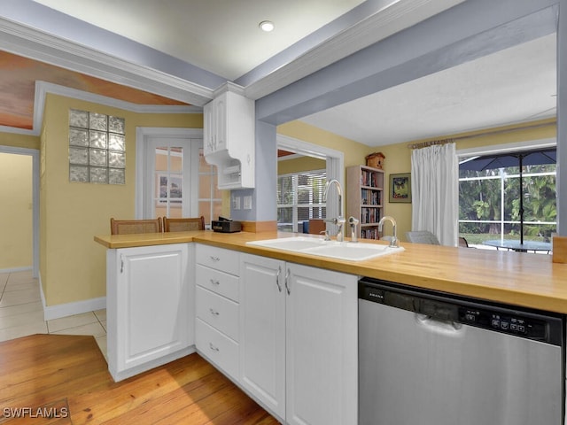 kitchen with dishwasher, a peninsula, a sink, and white cabinets