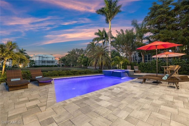 view of swimming pool featuring a patio area, fence, and a pool with connected hot tub