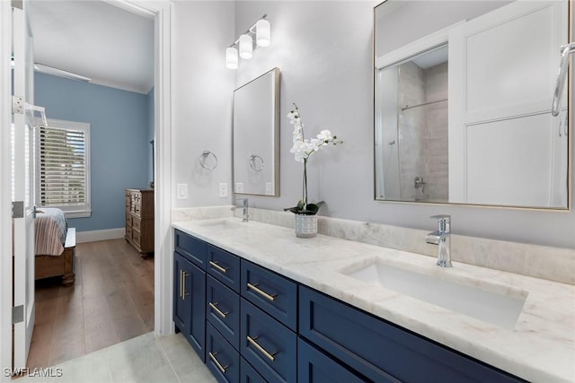 bathroom with a sink, ensuite bath, double vanity, and a tile shower